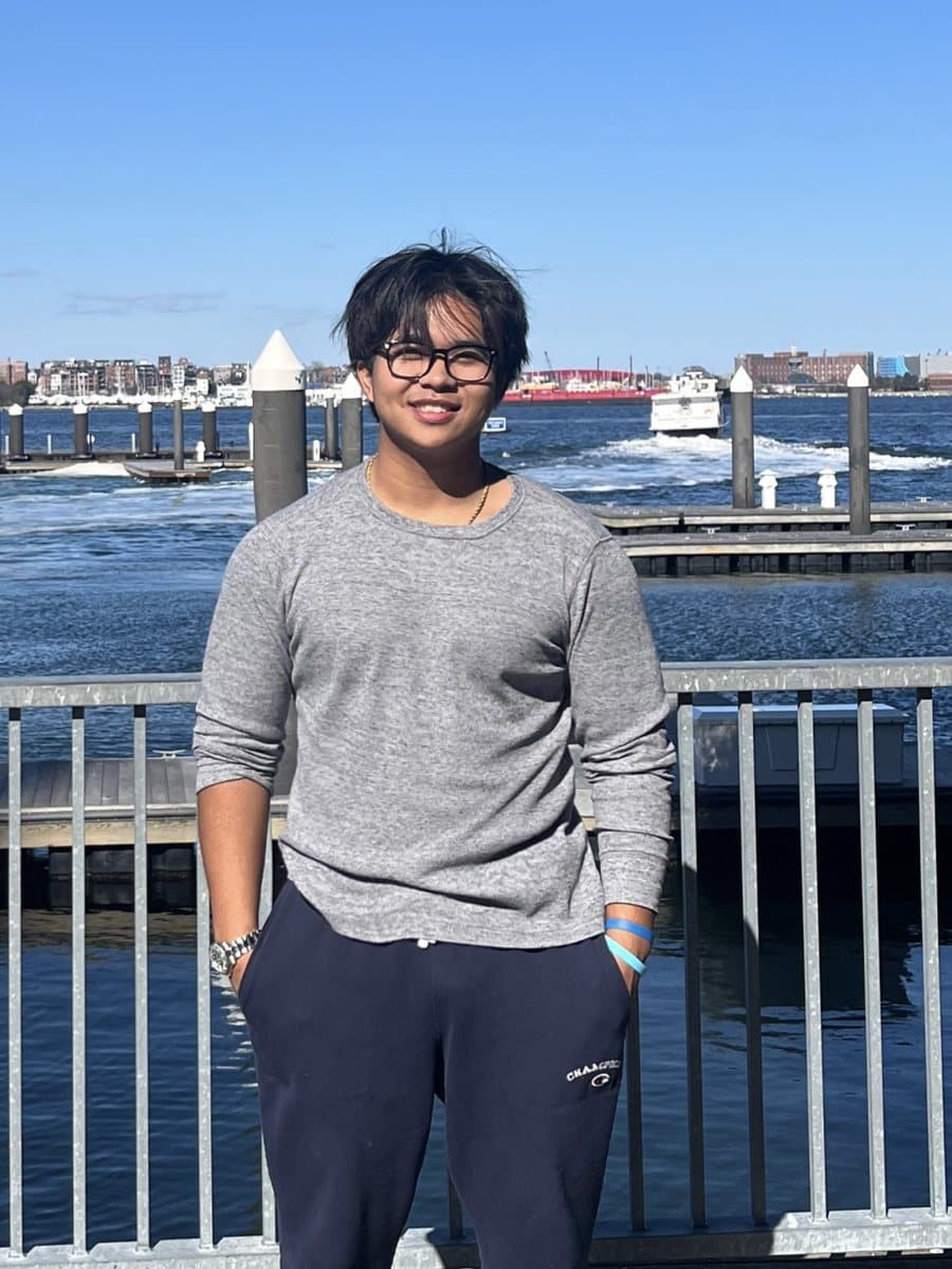 Simon Sang standing at a harbor on a sunny day